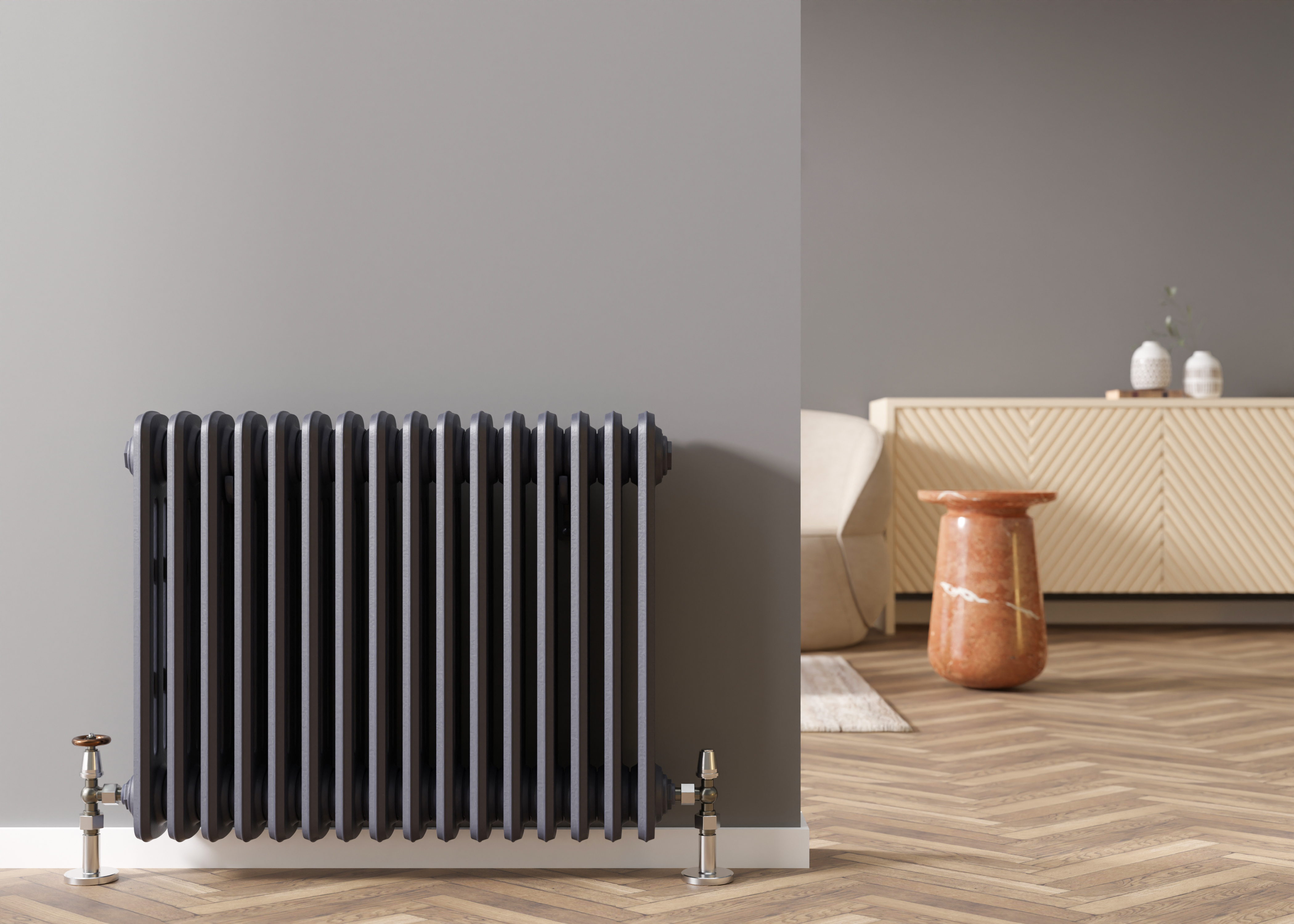 Black column radiator with chrome valves in a contemporary living room with herringbone wood flooring.