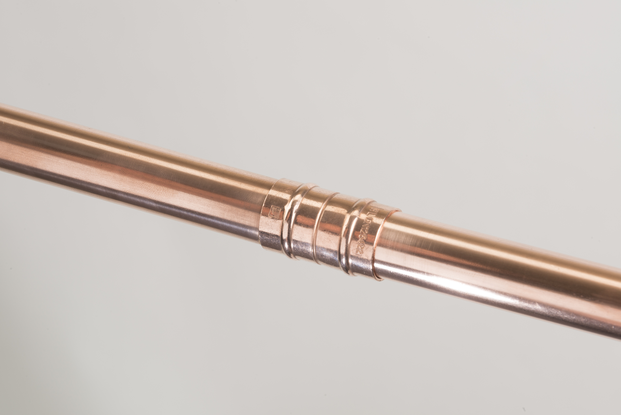 Close-up of a completed solder-ring fitting joining two copper pipes.